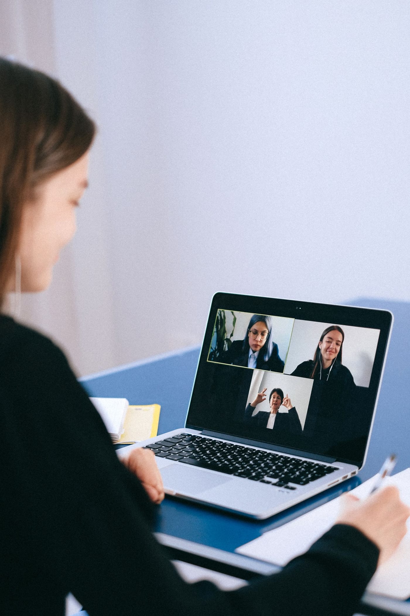 A laptop showing a group video call with several people on screen