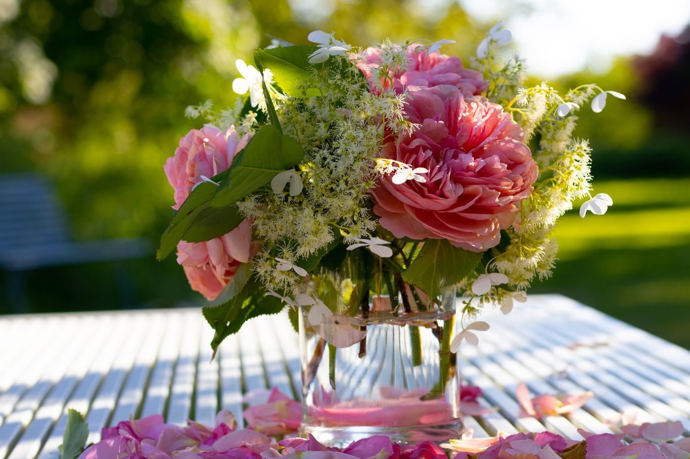 A beautiful bouquet of pink roses and hydrangeas in a glass vase, capturing the essence of summer