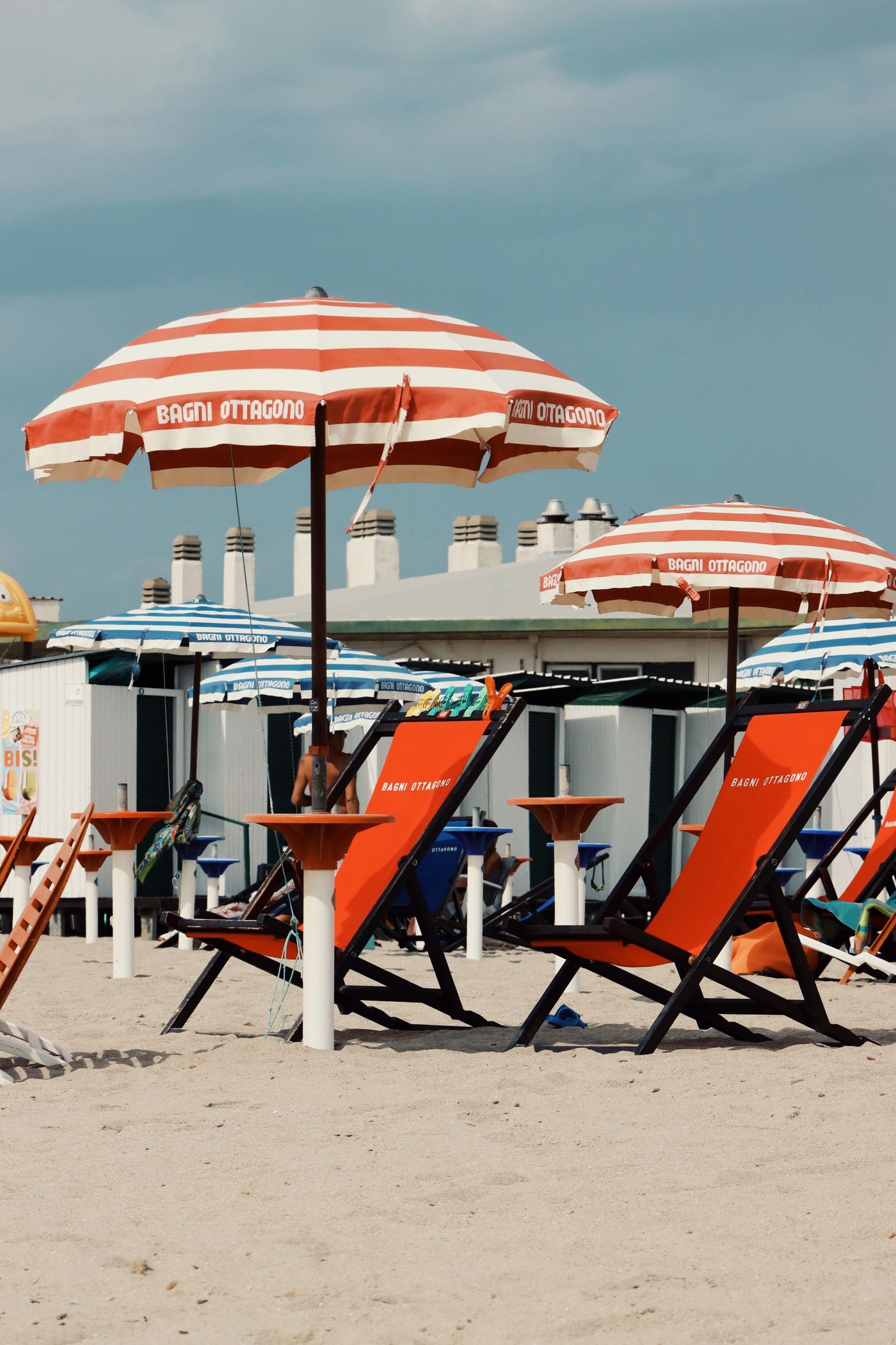 Vibrant striped umbrellas and chairs on a sunny Sardegna beach