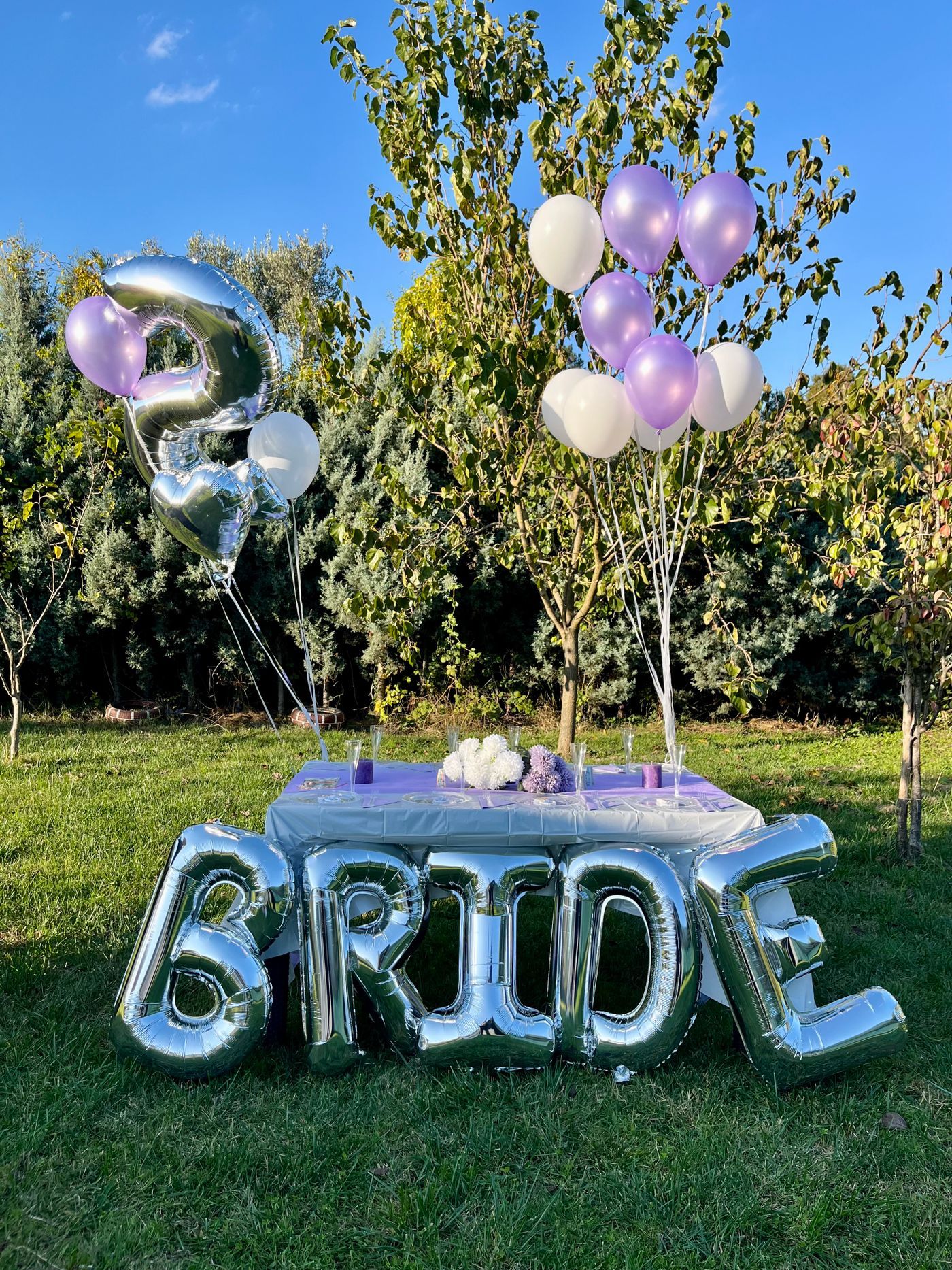 Elegant outdoor bridal shower with balloons and bride sign