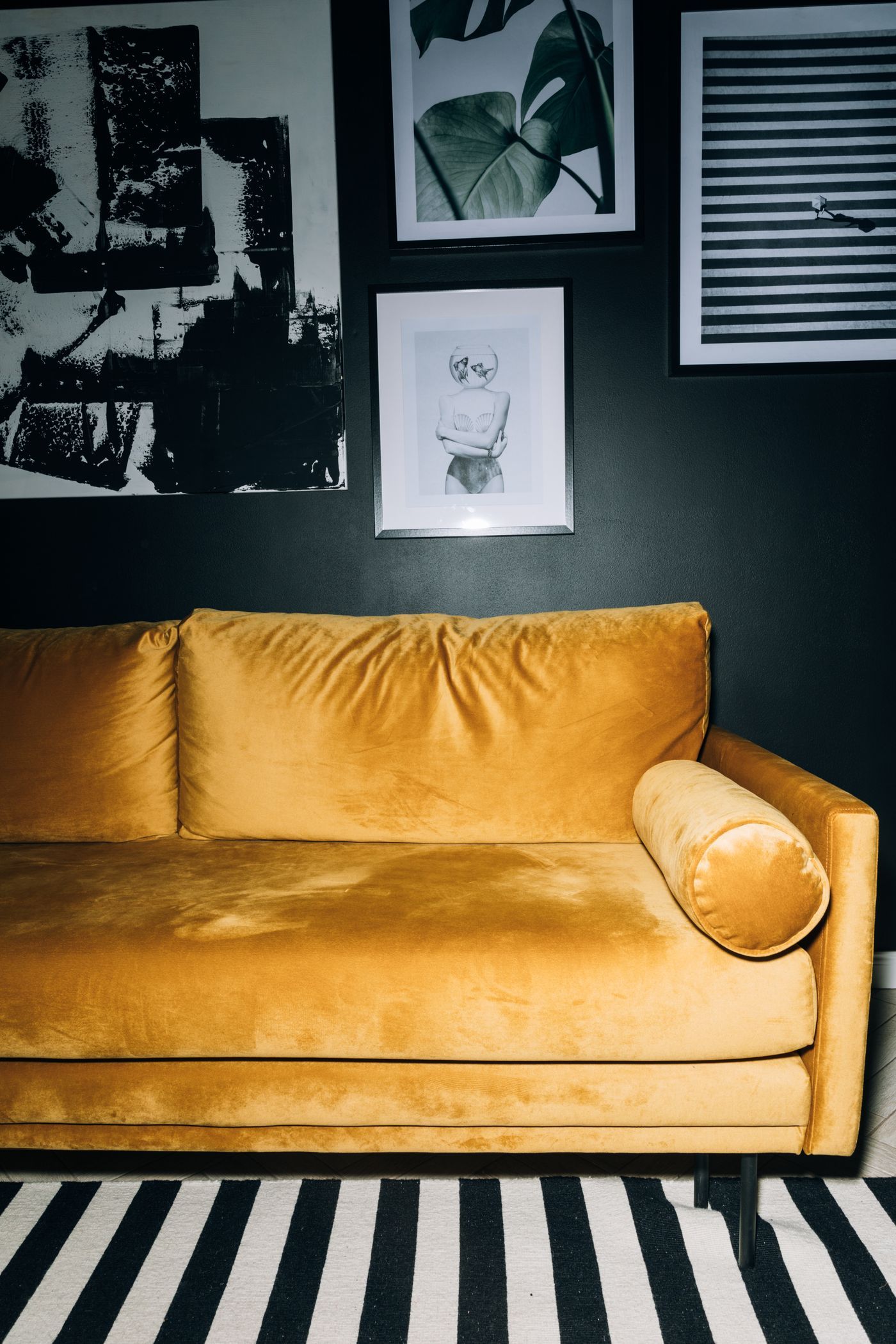 Chic living room featuring a yellow velvet sofa with contemporary art on the wall