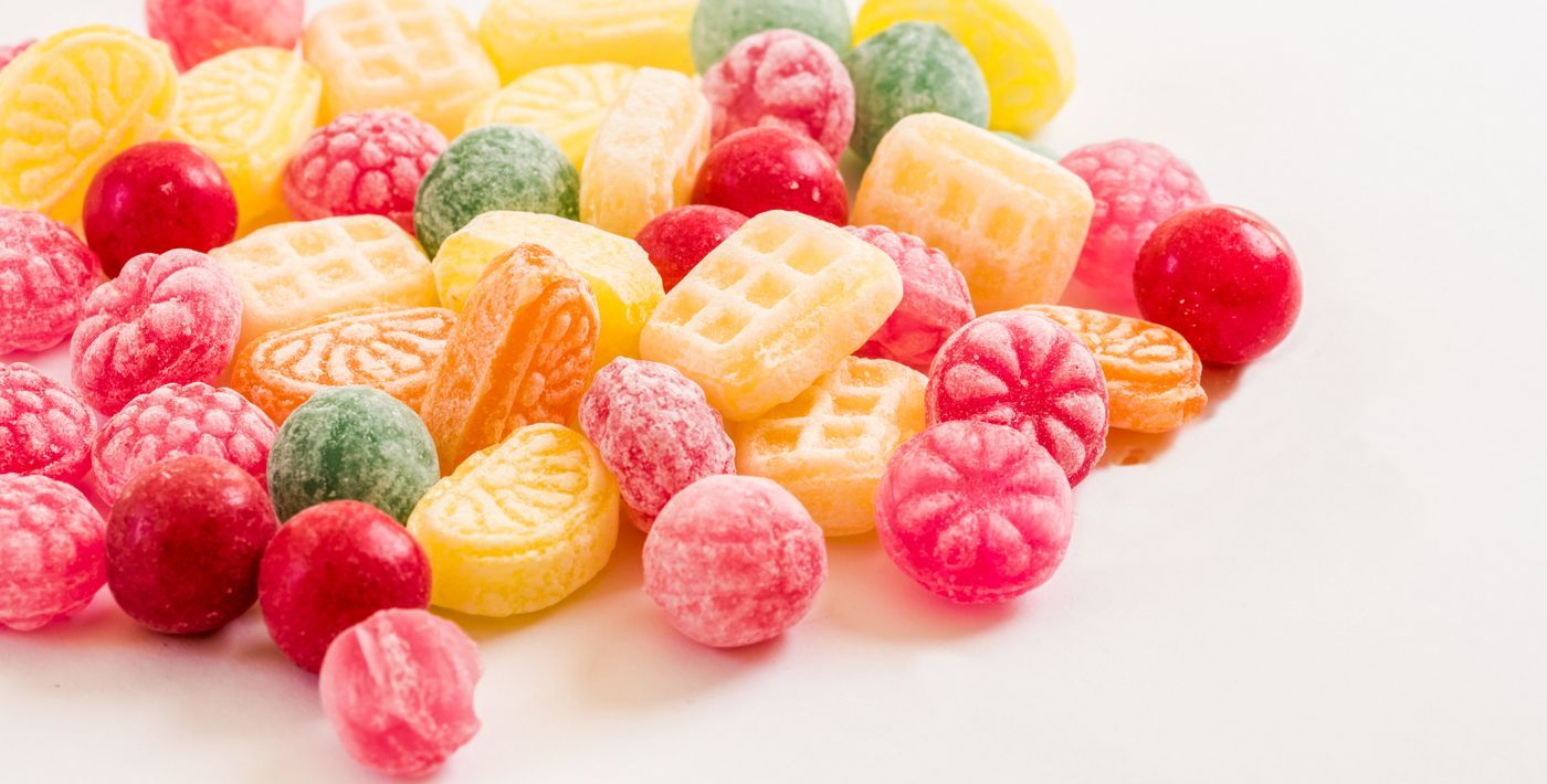 A vibrant display of assorted colorful hard candies on a white background