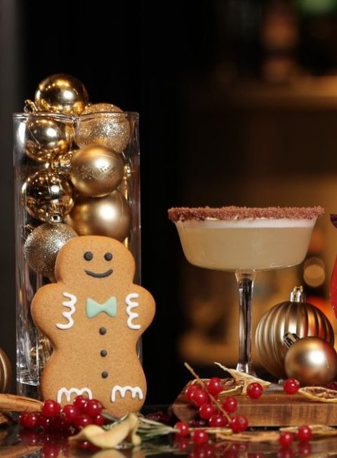 Image of gingerbread festive Christmas cocktail with baubles on the table.